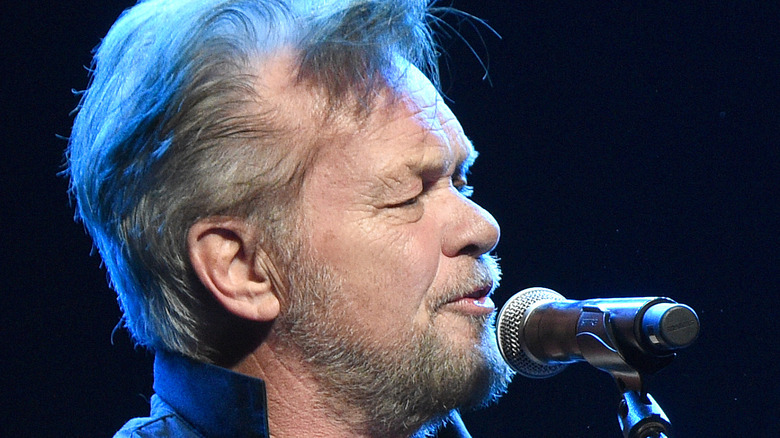 John Mellencamp singing while holding a guitar