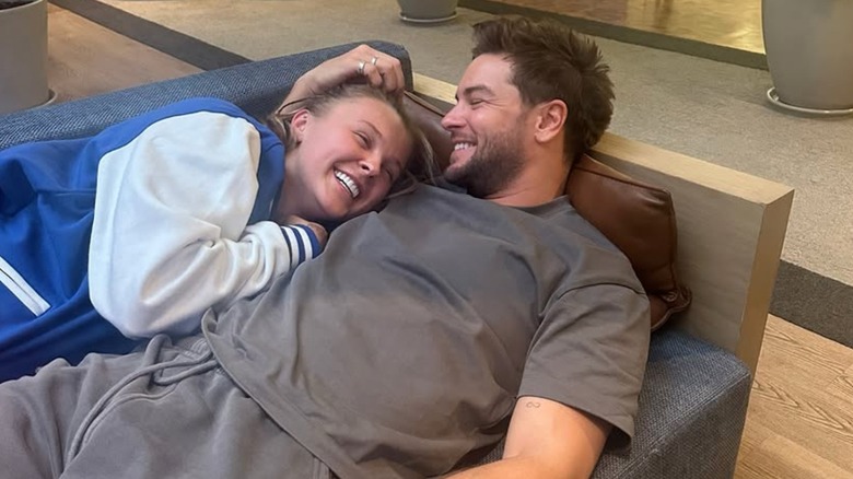 JoJo Siwa and Chris Hughes cuddling on a couch in 2025