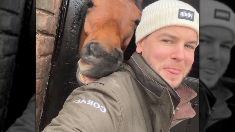 Chris Hughes posing with a horse