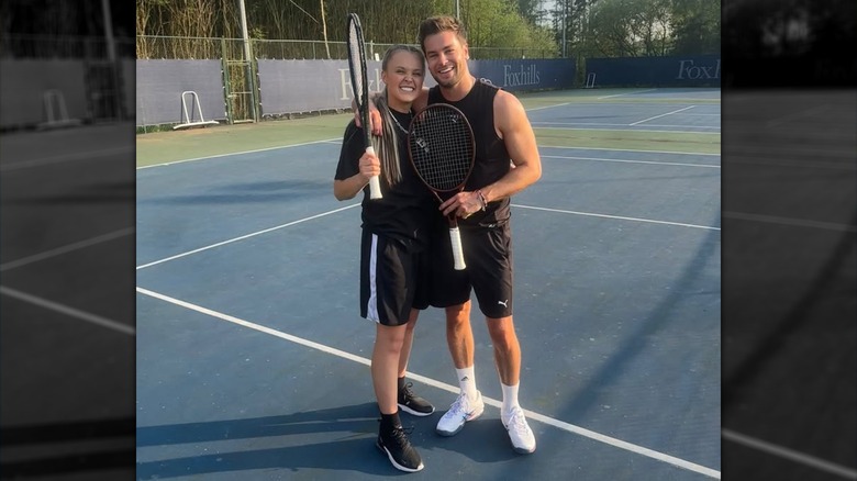 JoJo Siwa and Chris Hughes posing with tennis rackets after "Celebrity Big Brother U.K."
