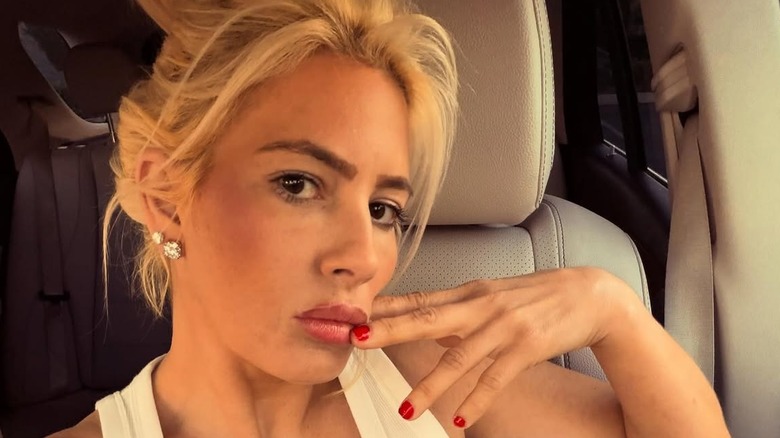 Shayne Lamas posing with her hand to her face in a 2025 car selfie