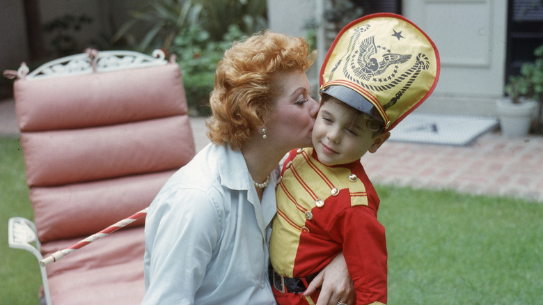 Lucille Ball kissing Desi Arnaz Jr. on the cheek.