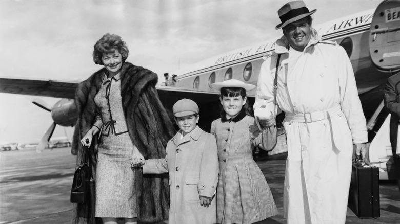 Lucille Ball, Desi Arnaz Jr., Lucie Arnaz, and Desi Arnaz walking away from a plane.