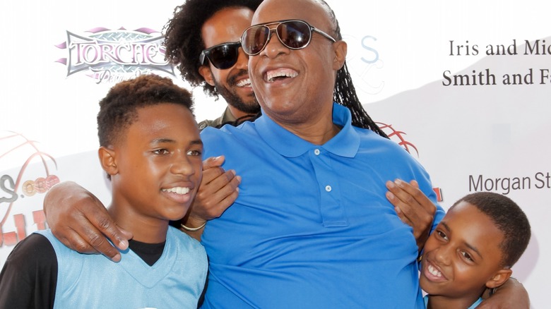 Stevie Wonder hugging his 3 children 