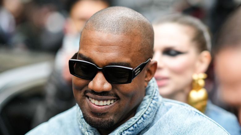 Kanye West smiling and wearing sunglasses