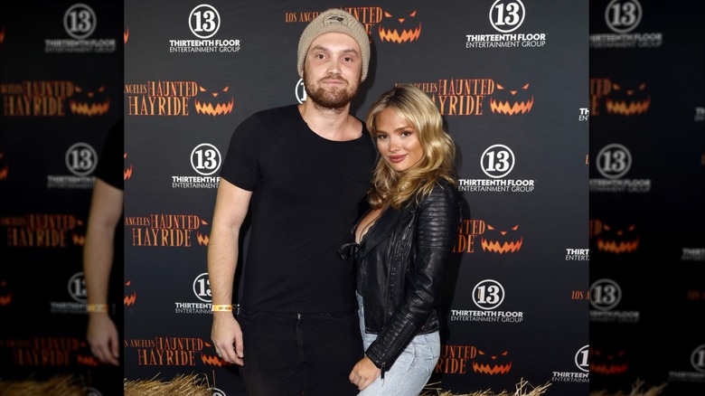 Kai Caster & Natalie Alyn Lind pose together on the red carpet for a Halloween event