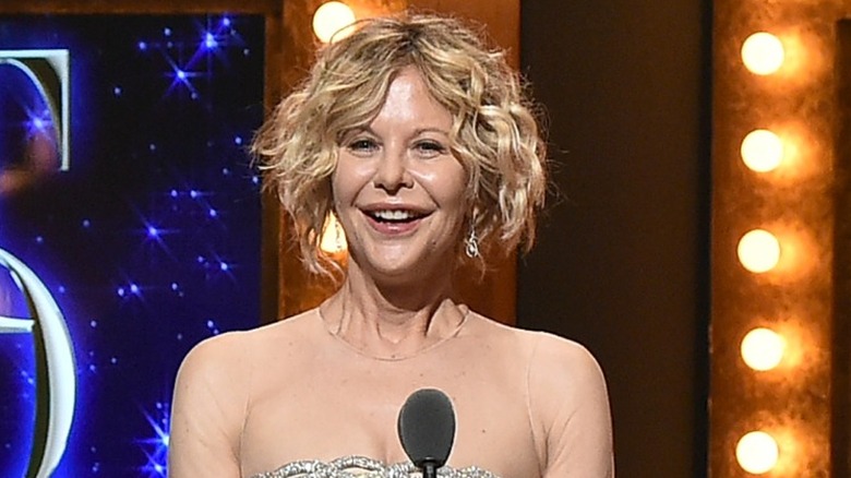 Meg Ryan smiling in a silver and beige dress at the Tony awards.