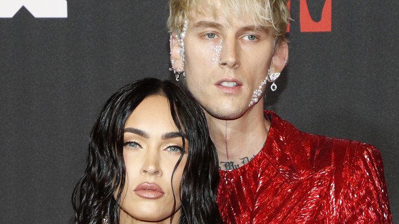 Megan Fox and MGK standing on the red carpet at the MTV Music Awards