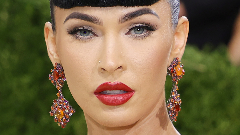 Megan Fox at the met gala in red lipstick and baby bangs