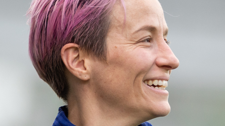 Megan Rapinoe holds up her awards