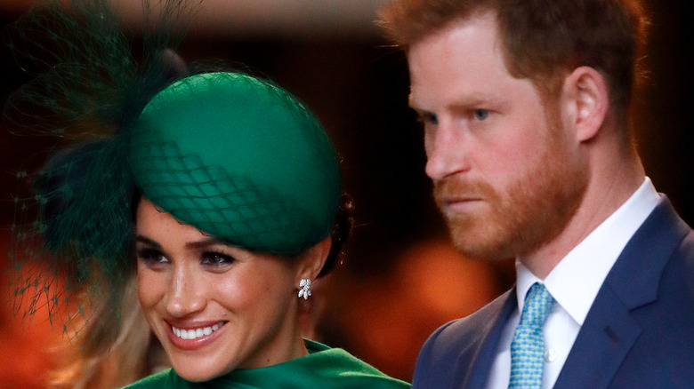 Meghan Markle smiling and Prince Harry straight-faced