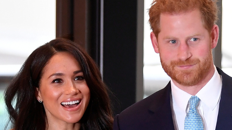 Meghan Markle and Prince Harry smiling at the camera