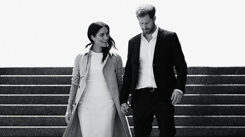 The poster for Netflix's "Harry & Meghan," showing the couple walking down a flight of stairs.