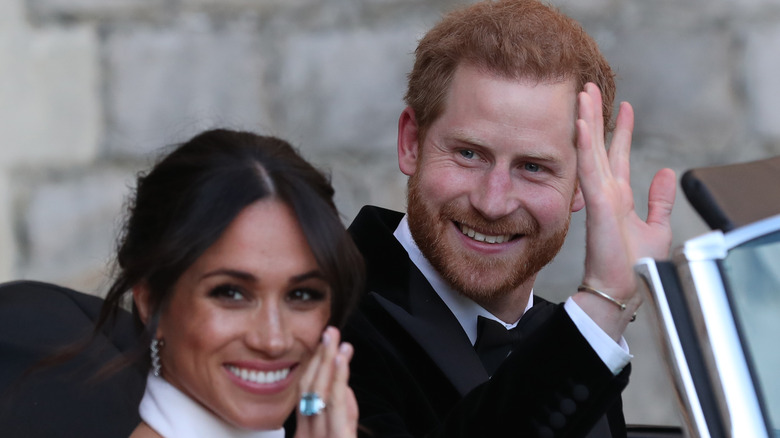 Prince Harry and Meghan Markle wave from a car on their wedding day