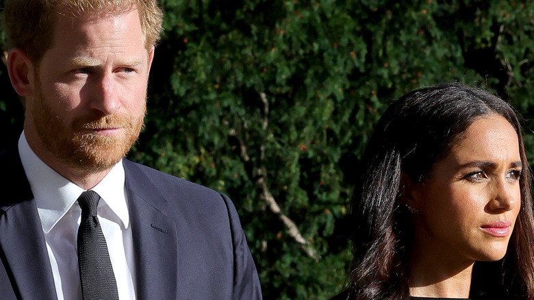 Prince Harry & Meghan Markle looking somber