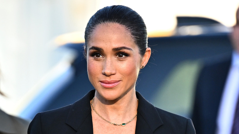 Meghan Markle in blue blazer and gold chain with hair pulled back