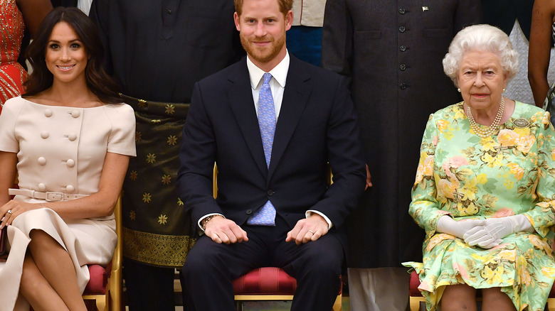 Meghan Markle, Prince Harry, and Queen Elizabeth posing