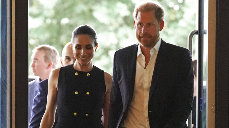 Prince Harry and Meghan Markle entering an estate hand in hand