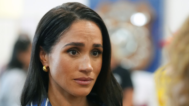 Meghan Markle listening with concerned expression