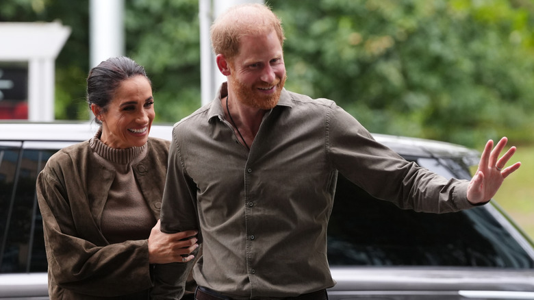 Meghan Markle smiling and Prince Harry waving