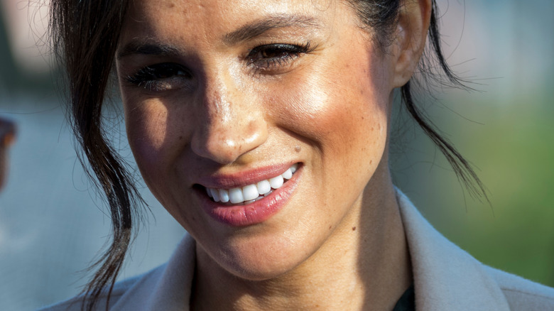 Meghan Markle smiling and listening