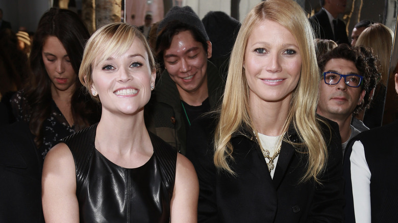 Gwyneth Paltrow and Reese Witherspoon sitting side-by-side at Fashion Week