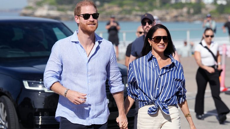 A smiling Prince Harry and Meghan Markle holding hands