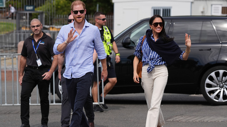 Meghan Markle and Prince Harry waving at a crowd
