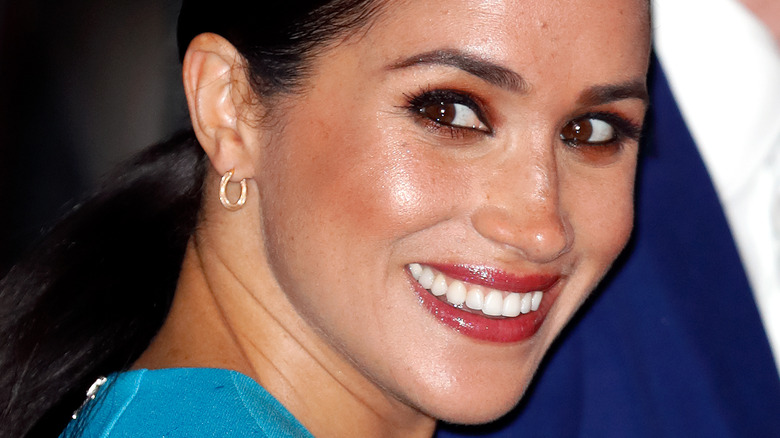 Meghan Markle in blue dress smiling 