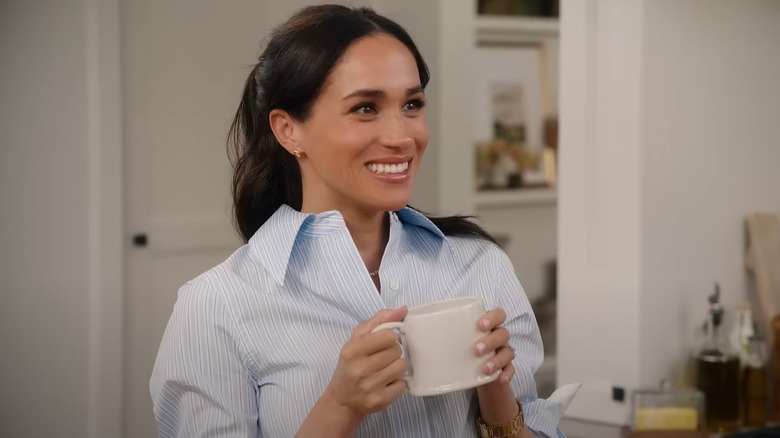 Meghan Markle smiling with a mug