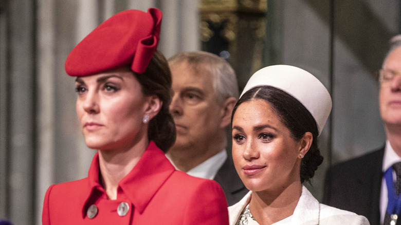 Meghan Markle, Duchess of Sussex standing behind Catherine, Princess of Wales