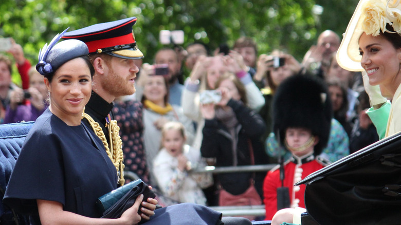 Prince Harry, Meghan Markle, and Kate Middleton riding in carriage