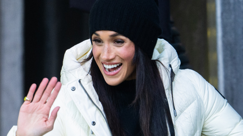 Meghan Markle smiling broadly while waving at fans