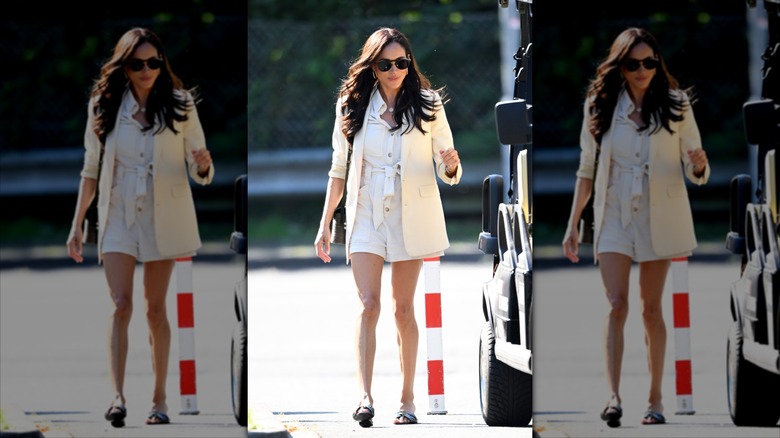 Meghan Markle walking on the street in sunglasses.