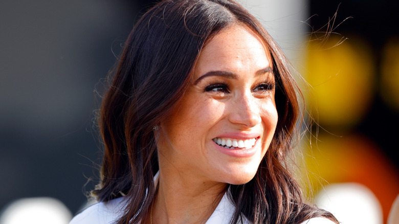 Meghan Markle smiling and looking to the side
