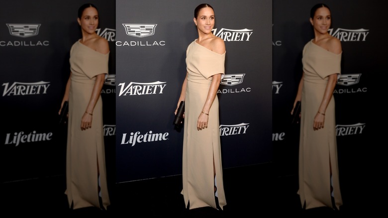 Meghan Markle posing in a beige gown