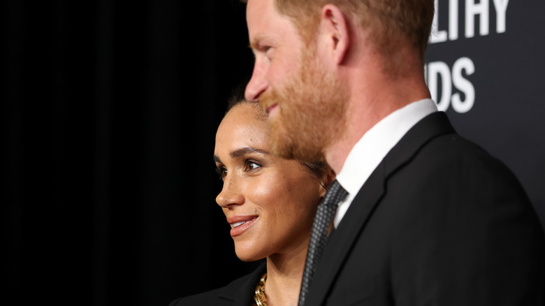 Meghan Markle smiling next to Prince Harry