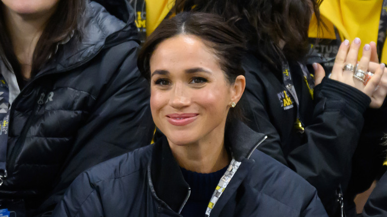 Meghan Markle smiling in a puffer jacket