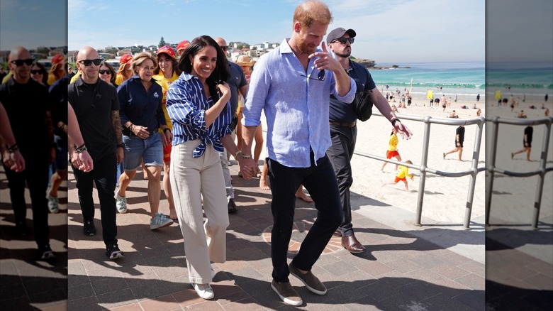 Meghan Markle and Prince Harry walking hand-in-hand in Australia by the beach