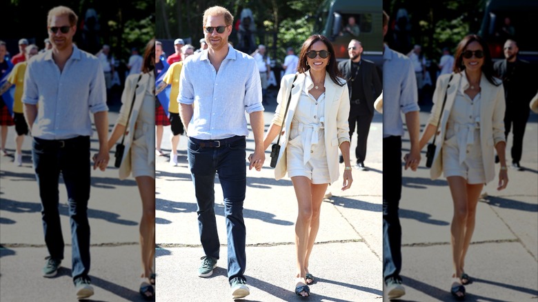 Prince Harry and Meghan Markle walking and holding hands at the 2023 Invictus Games