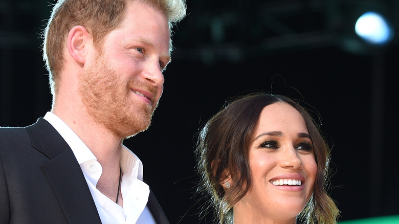 Meghan Markle and Harry posing on stage