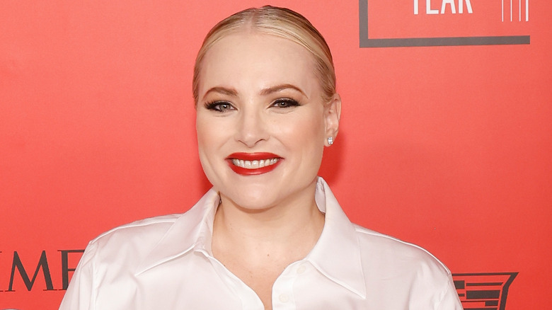 Meghan McCain white shirt red background