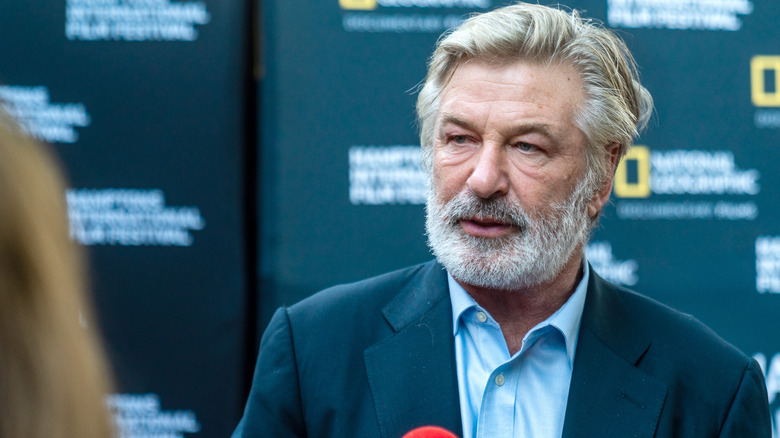 Alec Baldwin in front of a microphone