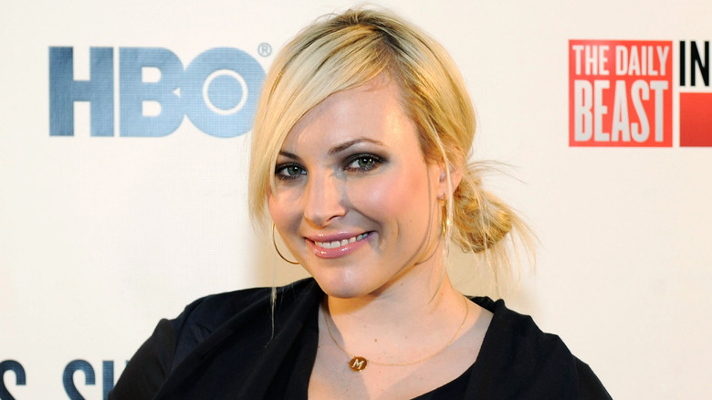 Meghan McCain smiling with side-swept bangs and a low messy bun.