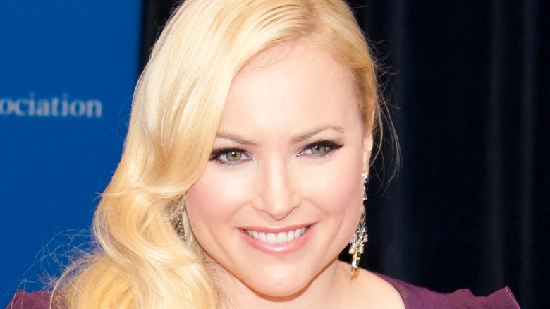 Meghan McCain smiles while wearing purple dress.