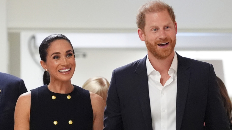 Meghan Markle and Prince Harry walking together and smiling