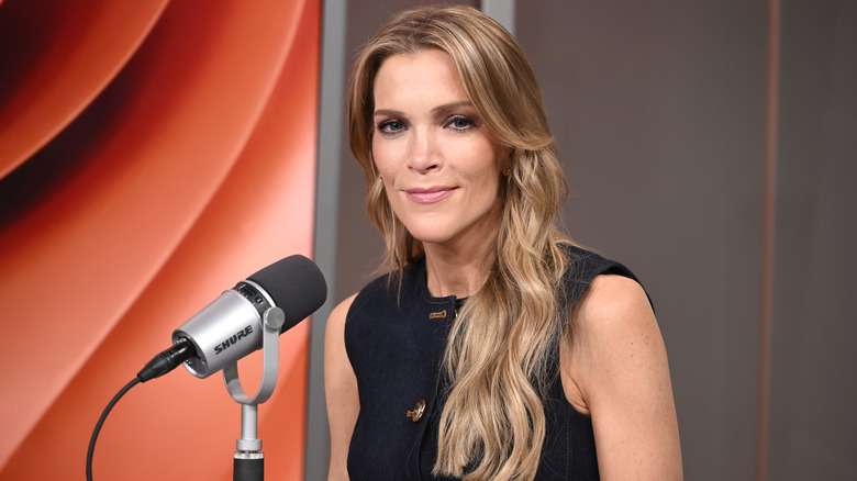 Megyn Kelly posing with her microphone in a black strapless dress