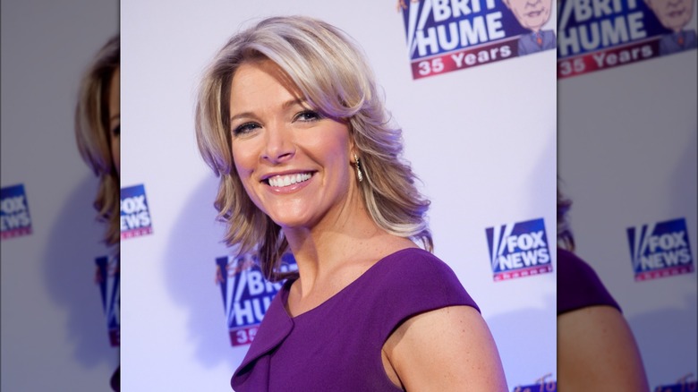 Megyn Kelly at an event in 2008 in a purple dress while smiling at the camera
