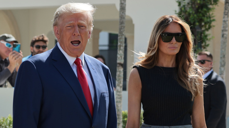 Donald Trump speaking with an unamused Melania Trump standing next to him