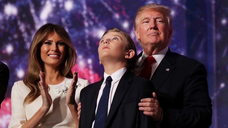 Melania, Barron, and Donald Trump stand together onstage